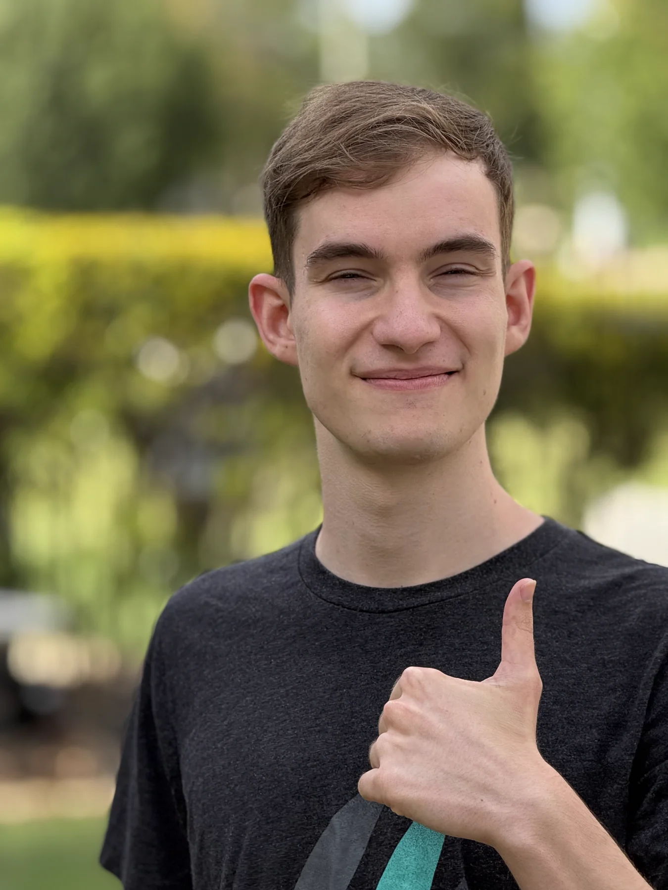 Zachary Debenport smiling and giving a thumbs up outdoors
